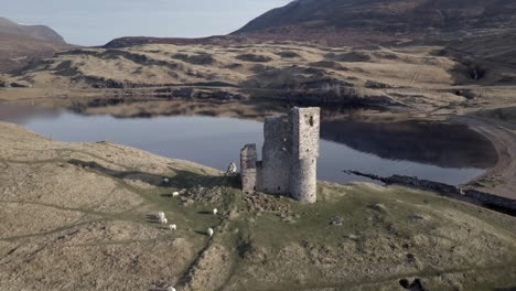 Aerial-footage-of-Ardvreck-Castle-ruin-on-the-banks-of-Loch-Assynt-in-Sutherland,-Scottish-Highlands,-Scotland