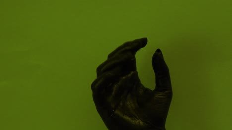 Junge-Weibliche-Handgemalt-Mit-Schwarzer-Farbe,-Die-Sich-Reibungslos-In-Einem-Grünen-Hintergrund-Bewegt