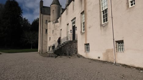 Drum-Castle-early-spring-morning-lady-climbs-front-steps-and-knocks-on-door