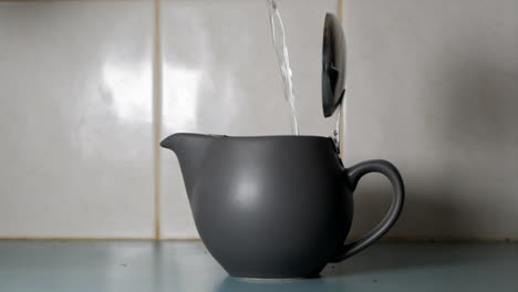 Hot-water-being-poured-into-a-modern-tea-pot