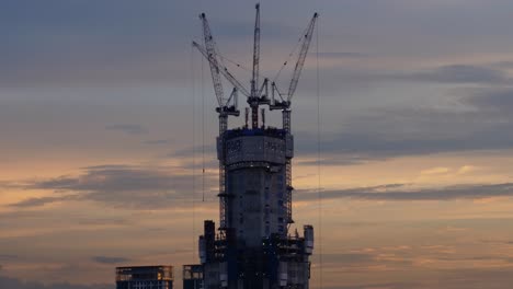 A-time-lapse-video-of-Crane-and-building-construction-site-against-blue-sky-with-a-enthralling-view-of-nightfall
