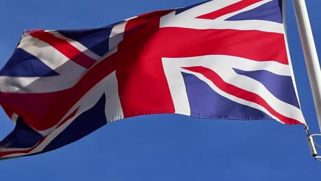 Die-Flagge-Des-Vereinigten-Königreichs-Bewegt-Sich-Im-Wind-Am-Blauen-Himmel