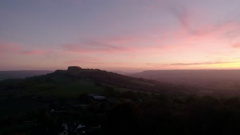 Langsame-Luftaufnahme-Seitwärts-Eines-Herrlichen-Roten-Sonnenuntergangs-über-Den-Grünen-Devon-Feldern-In-Und-Um-Die-Blackdown-Hills