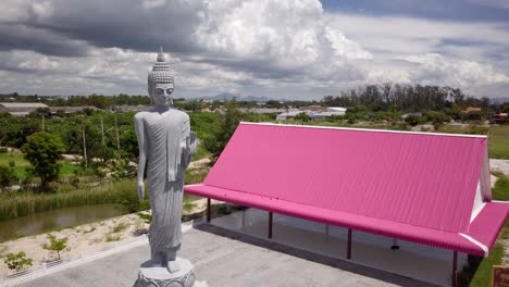 a-slow-rotation-around-a-standing-statue-of-Buddha,-Thailand