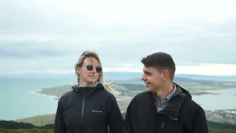 Junges-Attraktives-Paar,-Das-Auf-Dem-Gipfel-Eines-Hügels-In-Bluff-Neuseeland-Spaziert-–-Vorne-Aus-Nächster-Nähe