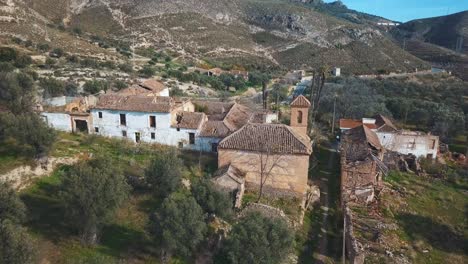 Aerial-view-of-an-abandoned-village-with-a-church-surrounded-by-nature-in-Spain