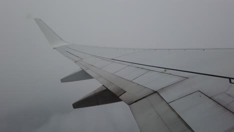 Vista-De-Un-Ala-De-Avión-Atravesando-Nubes-Y-Niebla