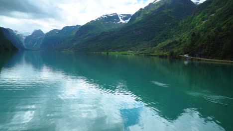Hermoso-Paisaje-Escandinavo-De-Noruega-Con-Piedras-De-Reflexión-De-Lago-Azul-Que-Rebotan-En-El-Paisaje-De-Montaña