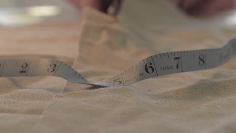 Seamstress-cuts-measured-cloth