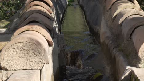 Old-arabic-aqueduct-with-flowing-water-in-slow-motion-in-Spain