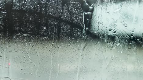 A-slow-motion-shot-of-rain-falling-on-a-windshield-wiper-as-seen-from-inside-a-vehicle