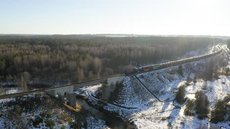 Cargo-train-crossing-bridge-during-winter