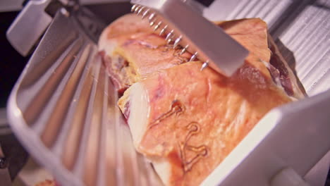 CLOSE-UP-Footage-of-Prosciutto-On-A-Steel-Slicer-DOLLY-shot