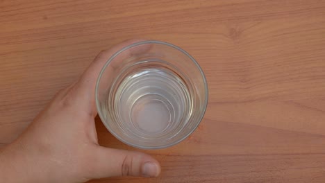 Frau-Nimmt-Rosa-Pillen-Und-Stellt-Ein-Glas-Wasser-Zurück-Auf-Den-Tisch