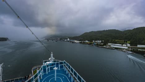 Time-lapse-overlooking-a-back,-stern-ship-deck,-while-pulling-away-from-an-Alaskan-port,-in-the-rain