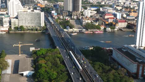 White-Train-Crosses-a-bridge-Saphan-Taksin,-Bangkok,-Thailand