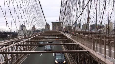 Standing-above-oncoming-traffic-on-Brooklyn-Bridge,-New-York