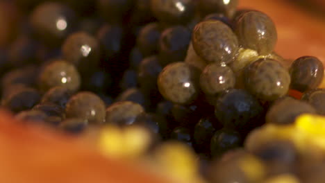 Zeitlupen-Makro-Nahaufnahme-Der-Samen,-Die-Aus-Einer-Köstlichen,-Frischen,-Saftigen-Papaya-Geschöpft-Werden