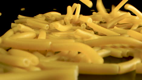 Slow-Motion-plus-Macro-Shot-Of-Falling-macaroni-on-pasta-in-black-table