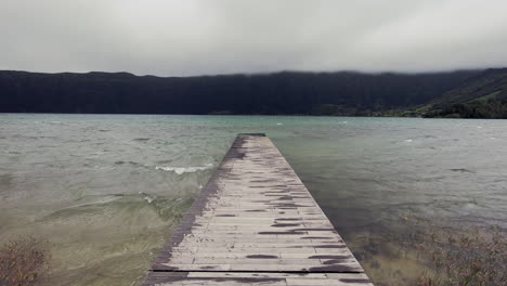 POV-shot-of-walking-on-a-small-wooden-pier-by-the-lake
