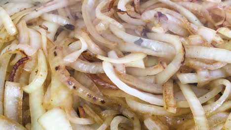Close-up-shot-of-some-burger-van-style-onions-being-fried-on-a-griddle-or-grill