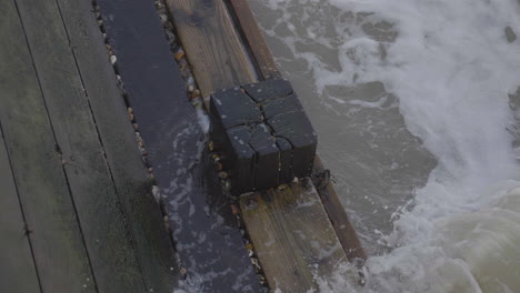 The-sea-flowing-round-a-wooden-pier-pylon-in-slow-motion