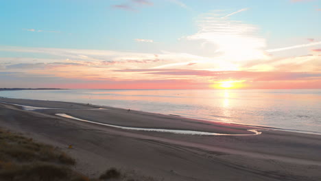 Eine-Ruhige-Ebbe-Am-Strand-In-Der-Nähe-Des-Sturmflutwehrs-Im-Südwesten-Der-Niederlande,-Während-Des-Sonnenuntergangs