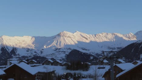 Timelapse-of-a-sunset-over-the-mountains-in-a-ski-resort-in-the-alps-with-village-in-foreground
