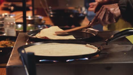 Slow-motion-shot-of-two-pans-with-crepes-in-a-street-market