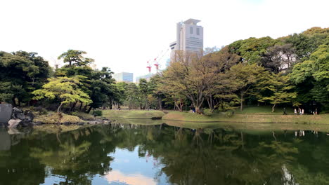 Amplia-Panorámica-Del-Lago-Del-Jardín-Botánico-Koishikawa-Con-árboles-Reflejados