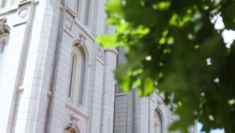 Panning-Shot-behind-a-tree-revealing-the-beautiful-Salt-Lake-City-LDS-Temple-on-a-clear-sunny-day
