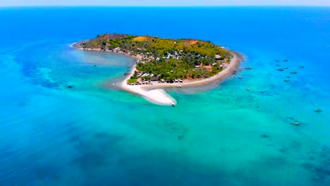 Aerial,-a-small-island-with-white-sand-beaches-in-the-middle-of-light-blue-ocean