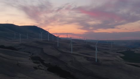 Beautiful-Aerial-Landscape-View-of-Wind-Turbines-on-a-Windy-Hill-during-a-colorful-sunrise
