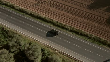 Aerial-view-of-a-black-car-going-on-a-trip-in-Spain