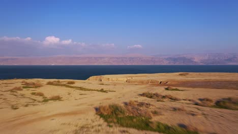 Aerial-shot-of-the-beautiful-Deadsea-red-desert,-fly-forward-to-the-sea,-shot-with-a-drone