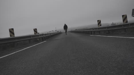 SlowMotion-footage-of-skater-doing-his-thing-on-icelandic-roads,-in-a-foggy,-dramatic-landscape