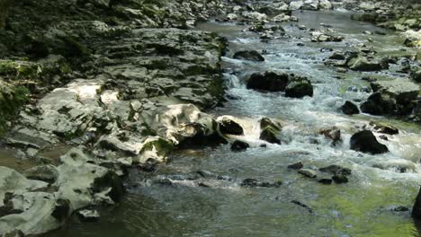 Close-up-of-flowing-clean-water-through-the-rocks