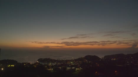 Golden-hour-time-lapse-over-the-city-of-St-George,-Grenada-with-the-lights-coming-on-at-night