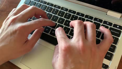 Hände-Tippen-Auf-Einem-Laptop-Computer-Mit-Natürlichem-Licht,-Das-Durch-Das-Bürofenster-Fällt
