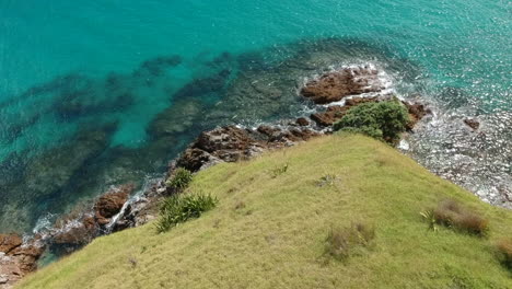 Aerial-view-of-a-rocky-coastline-of-a-small-island-at-Bay-of-Islands,-New-Zealand