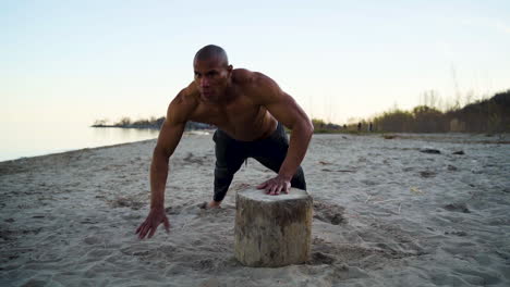 Muscular-athlete-doing-push-ups-on-a-beach-in-slow-motion
