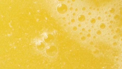 Closeup-Shot-of-bubbles-forming-and-fizzing-from-orange-water