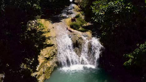 Aerial-view-up-of-tropical-Bohol-waterfall,-surrounded-by-lush,-tropical-green-foliage---paradise-woodland-green-trees