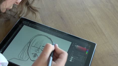 Concentrated-girl-drawing-on-a-graphics-tablet