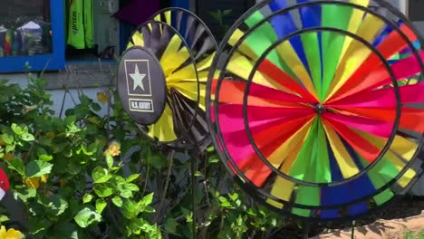 Colorful-and-bright-pinwheels-spinning-in-front-of-a-local-retail-store-that-specializes-in-kites,-wind-chimes,-windsocks,-and-other-lawn-accessories
