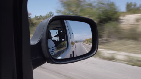 View-through-the-side-mirror-of-the-landscape-that-passes-between-Fes-and-Meknes-on-the-highway-in-Morocco