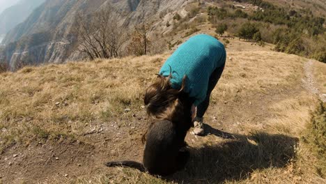 Girl-hugging-with-black-labrador-dog-on-a-mountain-in-autunm
