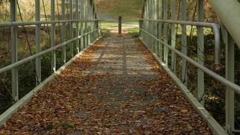 Metal-footbridge-over-a-scenic-creek-during-fall-or-autumn