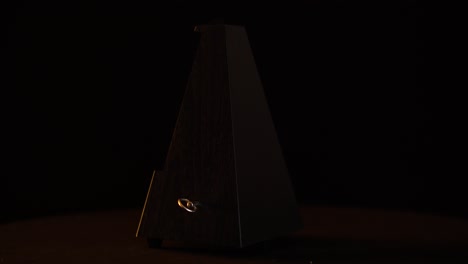 Metronome-with-pendulum-in-motion,-360-rotate-view-on-black-screen,-music-played-by-slow-rhythm