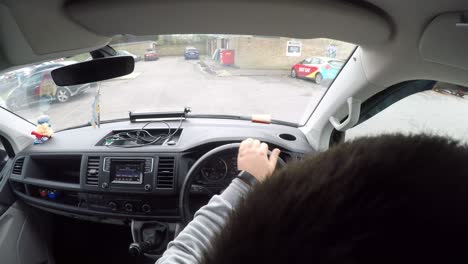 In-cab-shot-of-a-man-driving-a-van,-reverse-parking-in-a-car-park